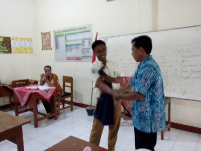 kepala-smpm-5-mengoleskan-lotion-pada-siswa-agar-terlihat-rapi