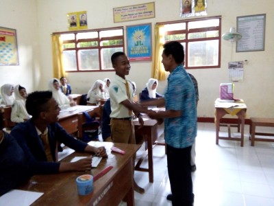 kepala-smpm-5-mengoleskan-lotion-pada-siswa-agar-terlihat-bersih