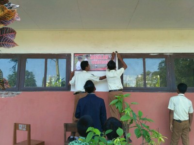 siswa-smpm5-didampingi-dewan-guru-memasang-slogan-di-sdn-1-buluagung